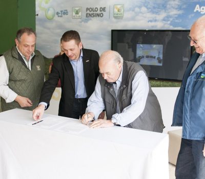 Presidente do Ibravin, Dirceu Scottá (de terno escuro), e o presidente do Conselho Administrativo do SENAR/RS, Carlos Sperotto (assinando o documento), renovam convênio para assistência técnica no setor vitivinícola
Foto: Tiago Francisco/Divulgação Farsul